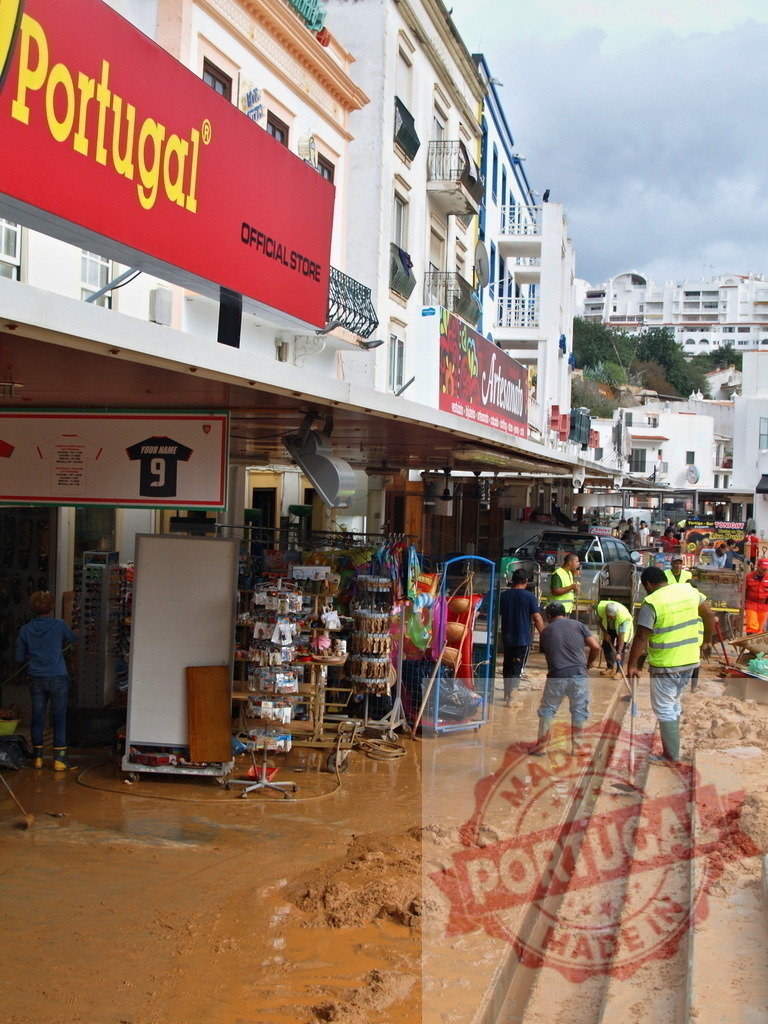 Albufeira flood mud cleanup on a street in Portugal | Albufeira Flood - discruction by weather problems Workers are cleaning thick mud from a street after a severe flood in Albufeira - Realisiert mit Pictrs.com
