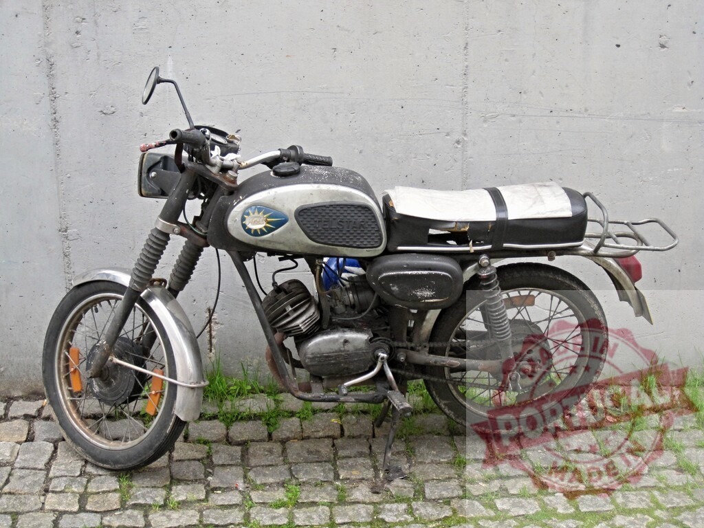 Vintage motorcycle parked against a concrete wall showing signs of age and wear | Old and rusty motorcycle parked against a concrete wall, showing signs of age and wear, evoking a sense of nostalgia and history - Realisiert mit Pictrs.com