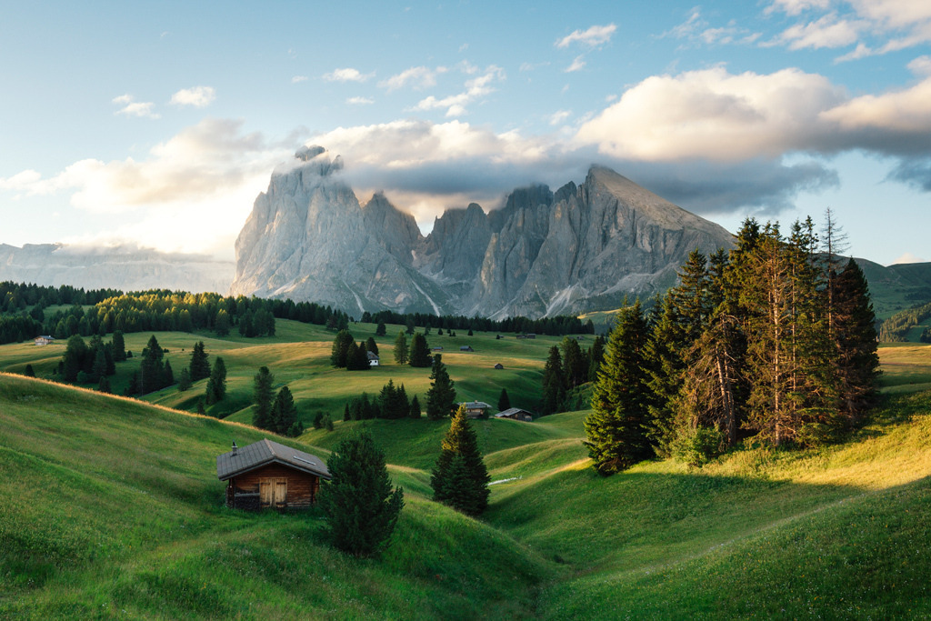 Morgenlicht über der Seiser Alm | Sanftes Morgenlicht taucht die weiten Wiesen der Seiser Alm in ein warmes Gold, während die markanten Gipfel von Langkofel und Plattkofel in den Himmel ragen. Eine friedliche Almlandschaft, die Ruhe und Weite ausstrahlt – ideal zum Innehalten und Träumen. - Realisiert mit Pictrs.com