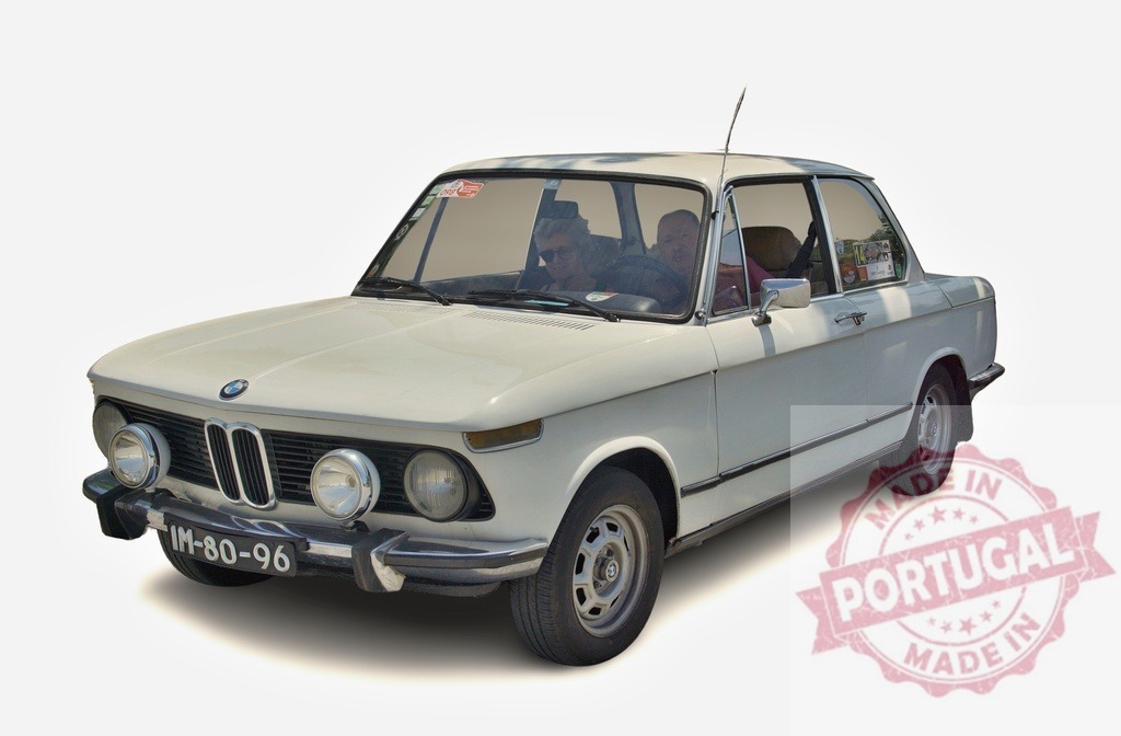 Vintage white BMW 1602 driving on a sunny day | White BMW 1602 with two passengers driving on a sunny day - Realisiert mit Pictrs.com