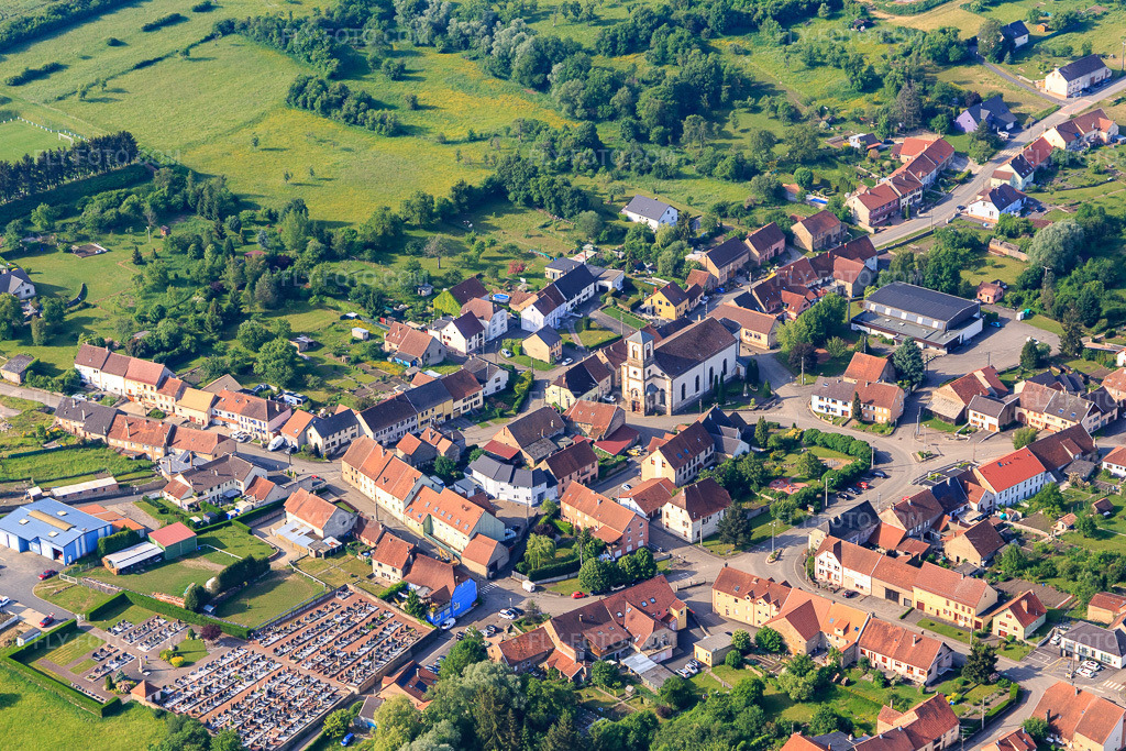 Aerial view: Village center with Eglise Saint-Barthelemy and cemetery in Wiesviller in the state Moselle, France. – Photo: IMG_107304.jpg taken on 05/19/2018 by Werner Riehm/FLY-FOTO.com – Resolution of the original: 5264 x 3510 px