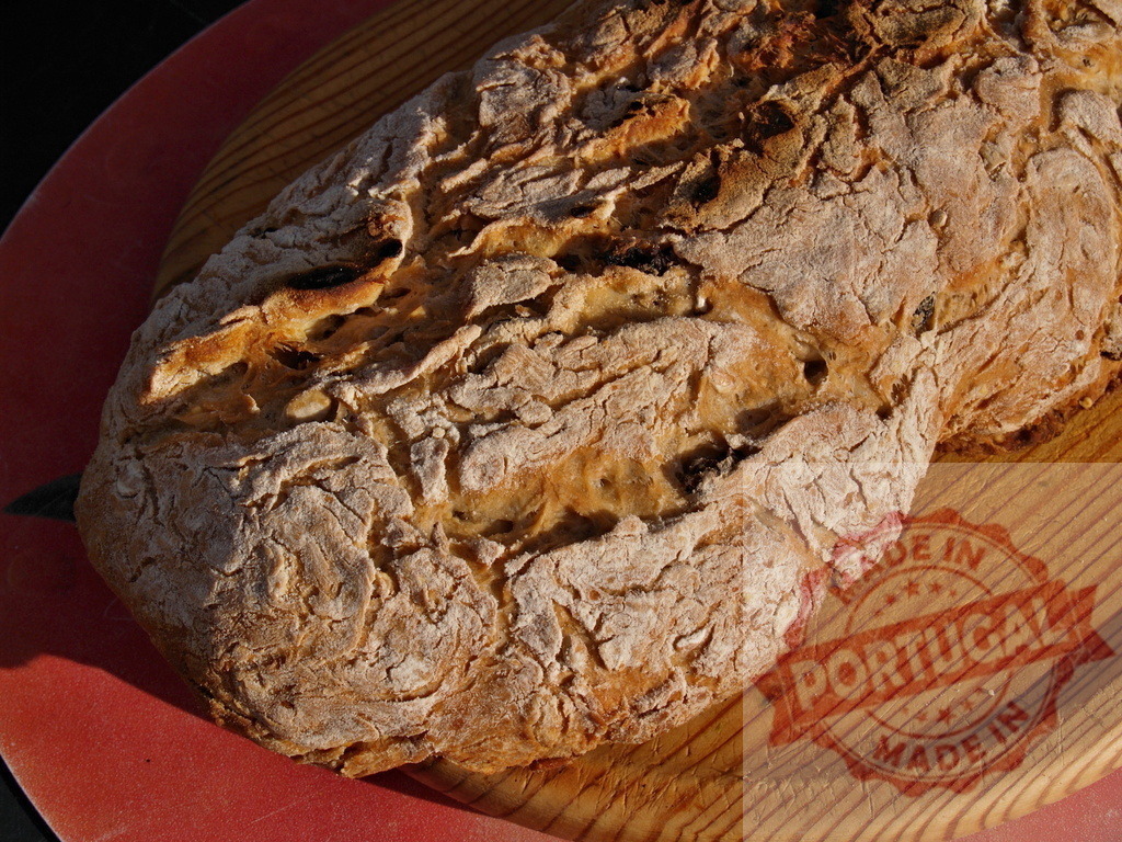 Homemade rustic bread loaf baking on cutting board | Fresh baked loaf of crusty bread sitting on a wooden cutting board - Realized with Pictrs.com