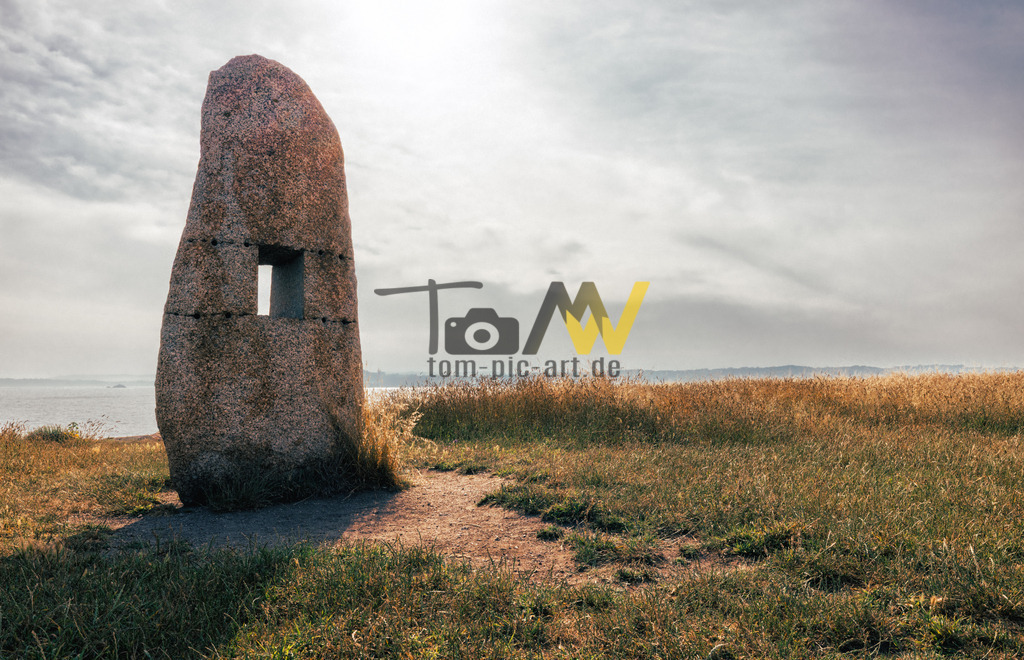 Das Denkmal "Menhire für den Frieden" in A Coruña, Spanien | Bei dem Objekt im Bild handelt es sich um das Denkmal "Menhire für den Frieden" (Menhires por la Paz) in A Coruña, Spanien. Es wurde 2001 vom Künstler Isaac Díaz Pardo geschaffen. Das Denkmal besteht aus Granitblöcken, die an prähistorische Megalithen erinnern sollen. Die rotbraunen Streifen auf den Steinen symbolisieren die Blutspuren von Gefangenen, die 1936/1937 an dieser Stelle erschossen wurden.  - Realisiert mit Pictrs.com