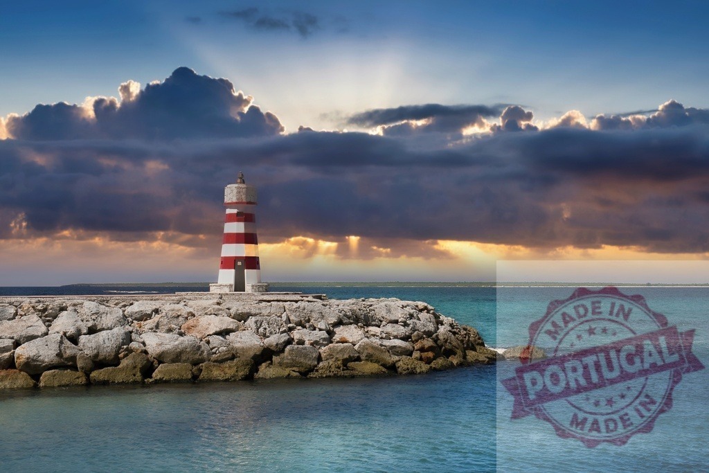 Lighthouse standing on rocky jetty at sunset | Lighthouse standing on a rock breakwater with dramatic clouds and sea at sunset - Realisiert mit Pictrs.com