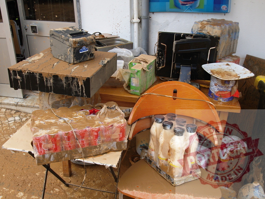 Flood aftermath leaving a trail of destruction and mud | Albufeira Flood - discruction by weather problems Mud-covered furniture and damaged merchandise demonstrate the devastating impact of a recent flood - Realized with Pictrs.com