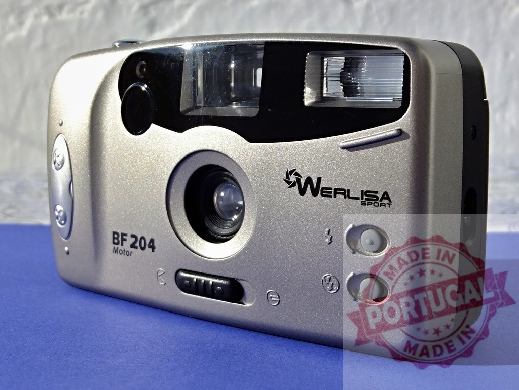 Werlisa BF 204 motor film camera laying blue background | Werlisa BF 204 motor film camera representing vintage photography technology - Realisiert mit Pictrs.com