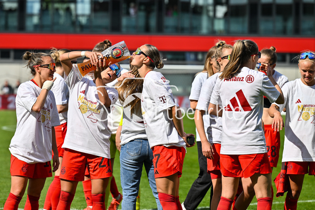 FC Bayern München - SC Freiburg | Die Spielerinnen des FC Bayern feiern die Meisterschaft nach dem Heimsieg gegen den SC Freiburg / Frauen Bundesliga: FC Bayern Muenchen - SC Freiburg, FC Bayern Campus am 27.04.2025 / Arianna CARUSO (FC Bayern Muenchen Frauen 27) gibt Klara BUEHL (FCB #17) einen Schluck auf dem Paulaner Bierkrug / Bierglas