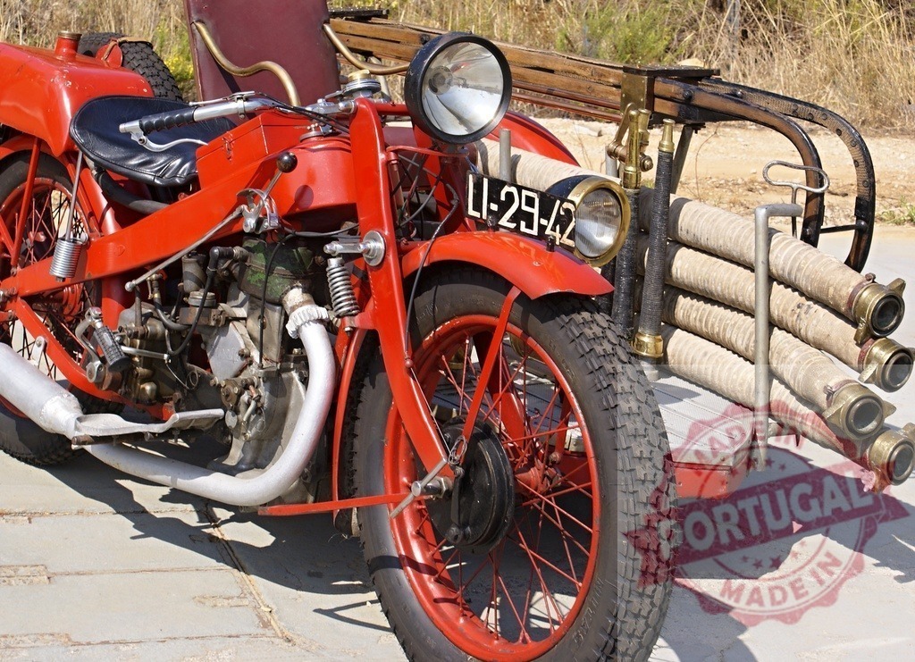 Vintage red motorcycle with sidecar carrying fire hoses | Antique red motorcycle and sidecar rigged with fire hoses for emergency services - Realisiert mit Pictrs.com