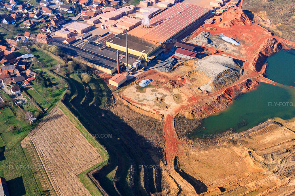 Aerial view: Clay pits and production halls of the Wienerberger brickworks Briqueterie Betschdorf in Betschdorf in the state Bas-Rhin, France. – Photo: IMG_62736.jpg taken on 03/09/2014 by Werner Riehm/FLY-FOTO.com – Resolution of the original: 4752 x 3168 px – wienerberger, leader mondial de la terre cuite : mur, toiture, façade