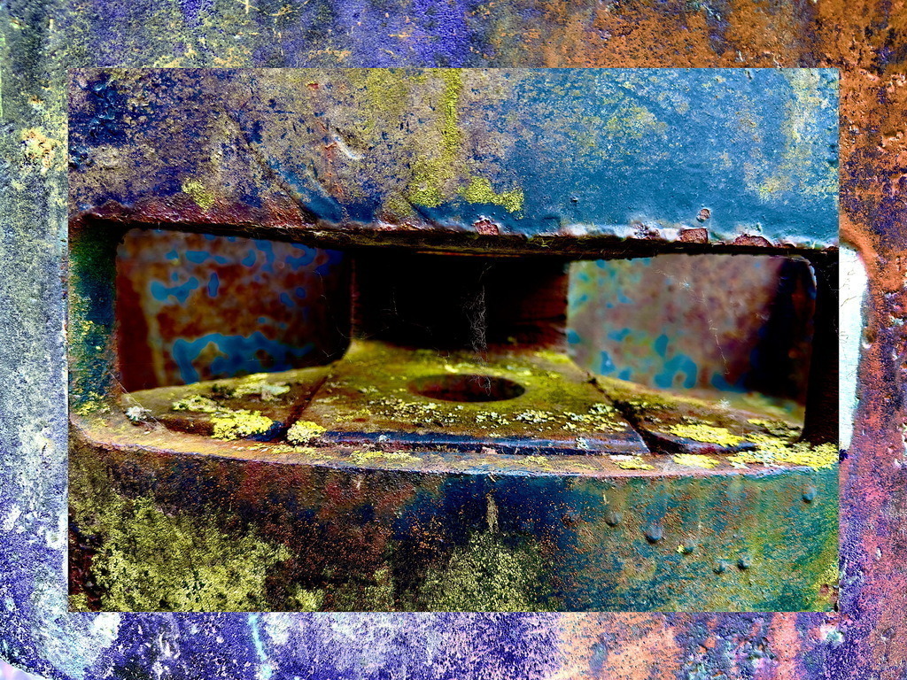 Patina und Rost liegen an der Schnittstelle zum Morgen… | Dieses Bild zeigt eine Nahaufnahme eines verrosteten industriellen Objekts. Die Texturen von Rost und Korrosion stehen im Vordergrund und verleihen dem Bild eine organische Qualität. Die Farbpalette ist vielfältig, mit dominierenden Blau- und Gelbtönen, die an Oxidationsprozesse erinnern. Die Komposition zieht den Betrachter in die Tiefe des Objekts, was durch die symmetrische Platzierung der Strukturen verstärkt wird. Das Werk spielt mit dem Kontrast zwischen dem Verfall und den lebendigen Farben, die durch die Korrosion entstehen. Es lädt dazu ein, die Schönheit im Verfall zu entdecken und zu reflektieren, wie sich Materialien im Laufe der Zeit verändern. Die fotografische Technik betont die Details, wodurch die Oberflächenstruktur fast fühlbar erscheint.  - Realisiert mit Pictrs.com