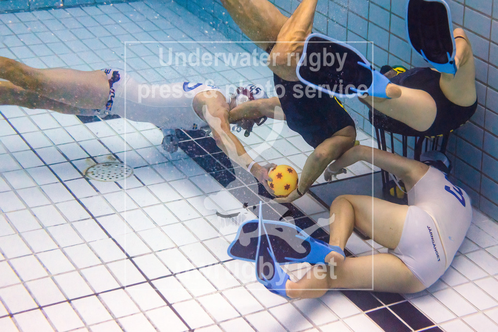 24. - 26.11.2023: Unterwasser-Rugby Champions Cup 2023  | Zwischenrunde Herren: Flipper (Dänemark) in blau gegen SDK Malmö Triton (Schweden) in weiß. Mattias Levin Persson (weiß #95) versucht vor dem dänischen Tor zu seinem Mitspieler Jesper Larsson (weiß #3) zu passen. Der Pass wird jedoch Mick Steen Nielsen (blau #31) abgefangen. - Realisiert mit Pictrs.com