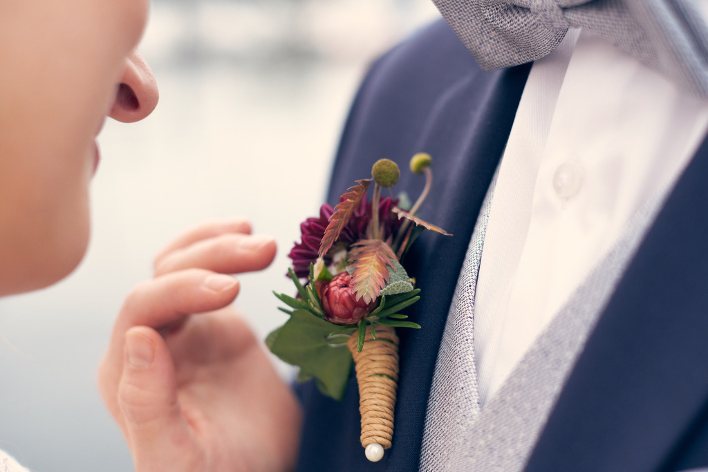 Braut berührt liebevoll das Blumengesteck des Bräutigams | Austria - October 08, 2022: Braut berührt liebevoll das Blumengesteck des Bräutigams. - Realisiert mit Pictrs.com