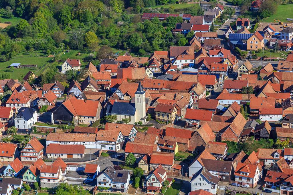 Aerial view: Village overview from the southeast with church in Engwiller in the state Bas-Rhin, France. – Photo: IMG_099438.jpg taken on 04/30/2017 by Werner Riehm/FLY-FOTO.com – Resolution of the original: 5245 x 3497 px