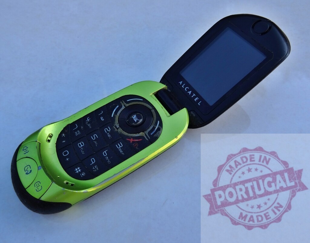 Old green Alcatel flip phone showing keypad and blank screen | Green Alcatel flip phone open showing keypad and blank screen on a white background - Realisiert mit Pictrs.com