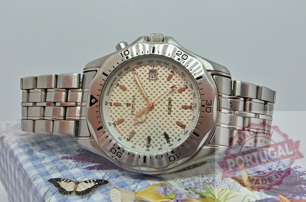 Stainless steel wristwatch displaying time and luxury accessory on box | Stainless steel wristwatch showing time on a decorative box with a butterfly - Realized with Pictrs.com