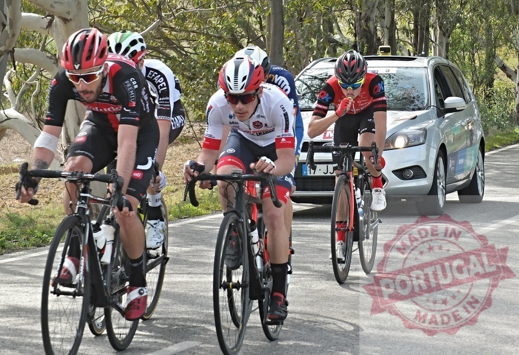 Cyclists racing on road with team support vehicle | Professional cyclists competing in a road race with a follow car - Realisiert mit Pictrs.com