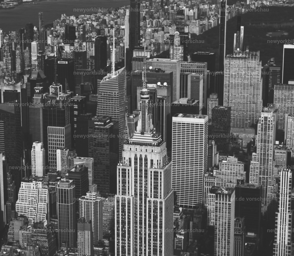 Ikone in Kontrasten – Empire State Building aus der Luft in Schwarz/Weiß | Das Empire State Building in einer Perspektive, die seine ganze Kraft und Eleganz zeigt: aus der Luft, in kontrastreichem Schwarz/Weiß. Diese Aufnahme reduziert die Metropole auf ihre Essenz – klare Linien, monumentale Architektur und die unverwechselbare Silhouette eines der berühmtesten Wahrzeichen der Welt. Die Skyline von Manhattan wirkt in dieser Darstellung zeitlos und kraftvoll, während Licht und Schatten ein Spiel aus Tiefe und Struktur erzeugen. Schwarz/Weiß verleiht dem Motiv eine klassische Note, die die Geschichte und die Bedeutung des Empire State Building unterstreicht. Ein Bild, das nicht nur Architektur zeigt, sondern die Seele einer Stadt, die niemals schläft.