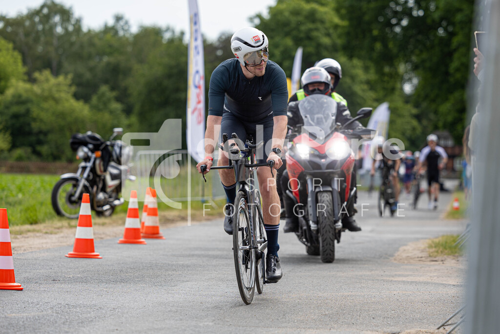 Auch das Einhalten der Regeln gehört bei einem offiziellen Triathlon dazu - dieser Radfahrer hat das Kampfrichtermotorrad quasi im Nacken. | immodelaporte-sportfotos - Realisiert mit Pictrs.com