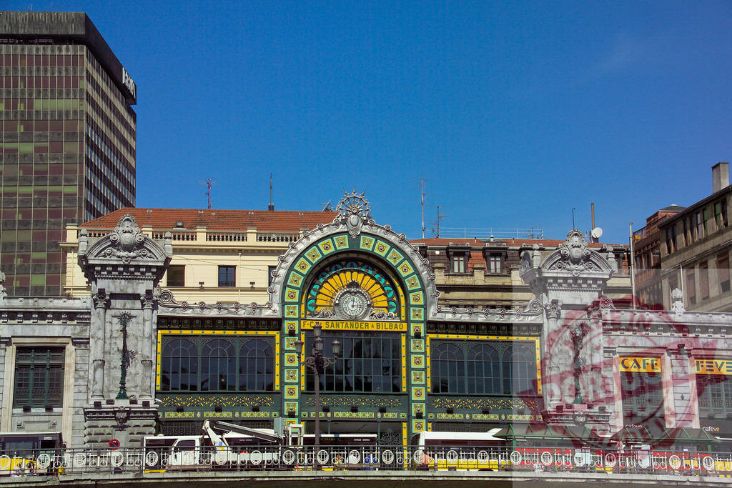 Ornate facade of La Concordia Station in Bilbao. Spain - Bilbao | La Concordia Station showing art nouveau architecture and stained glass under blue sky - Realisiert mit Pictrs.com