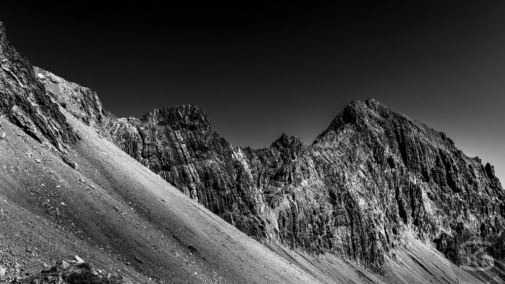 The Sublime Heights - Schwarzweiß Hochgebirge Fotografie | Stefan Kuhn | Monumentale Schwarzweiß-Serie des Hochgebirges von Stefan Kuhn. Acht kontraststarke Fotografien zeigen schroffe Alpengipfel vor tiefschwarzem Himmel – eine eindringliche Darstellung von Erhabenheit, Stille und der archaischen Kraft der Berge in radikaler Reduktion. - Realisiert mit Pictrs.com
