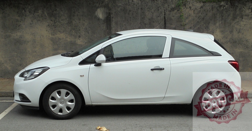 White Opel Corsa hatchback car parked in street | White Opel Corsa 3-door hatchback parked on a street next to a wall - Realisiert mit Pictrs.com