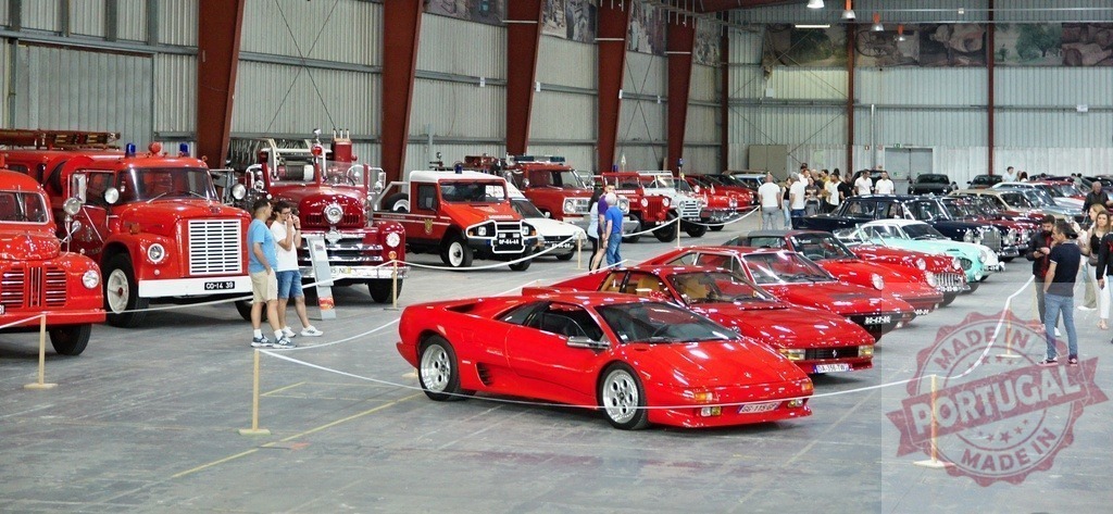 Visitors admiring classic cars and fire trucks at exhibition | People looking at vintage vehicles parked inside a large building during an auto show - Realized with Pictrs.com