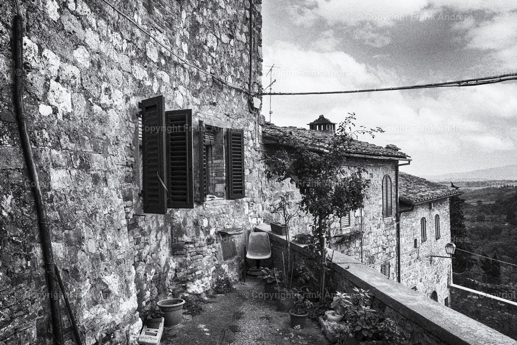 Auf den Straßen der Toskana | Mein Lieblingshaus in der bezaubernden Altstadt von San Gimignano.
Altes Haus in der mittelalterlichen Kleinstadt von San Gimignano in der Toskana. Blick von der Terrasse auf die traumhafte Landschaft der Toskana. Stadtfotografie aus Italien in schwarz weiß - Realisiert mit Pictrs.com