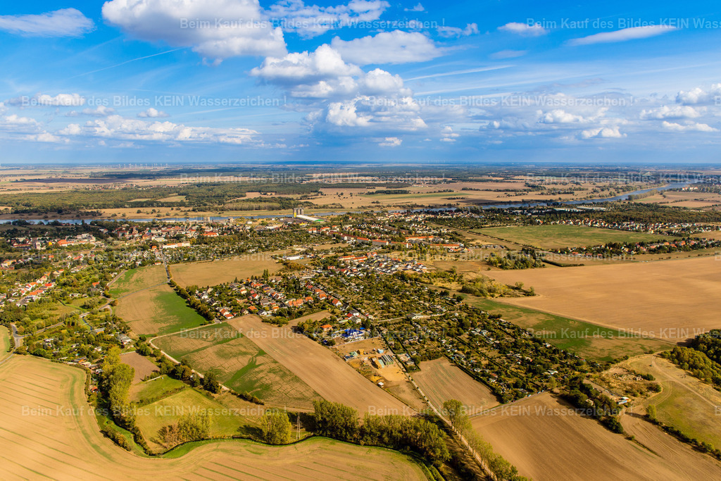 Magdeburg Salbke Spionskopf-0753 | Der Spionskopf liegt am südlichen Rand Magdeburgs im Stadtteil Salbke. Hier geht die städtische Bebauung allmählich in die offene Landschaft über. Felder, Kleingärten, Einfamilienhäuser und gewachsene Wohnbereiche prägen das Umfeld. Wer hier lebt, erlebt Magdeburg von einer ruhigeren Seite – mit mehr Abstand zum dicht bebauten Stadtzentrum und viel Landschaft in der unmittelbaren Umgebung. –  – Die Lage am südlichen Stadtrand verbindet das Wohnen im Grünen mit der Zugehörigkeit zur Landeshauptstadt. Rund um Salbke wechseln sich Siedlungsbereiche und landwirtschaftlich genutzte Flächen ab. Je nach Jahreszeit verändert sich das Bild: Im Sommer leuchten die Felder in warmen Farben, während Baumreihen und Grünflächen die Wohngebiete gliedern. –  – Der Spionskopf liegt außerdem in der Nähe des Flugplatzes Magdeburg-Süd. Die besondere Lage macht diesen Bereich zu einem interessanten Übergang zwischen Stadt, Landschaft und Luftfahrt. Aus der Vogelperspektive wird sichtbar, wie weit sich die Wohngebiete in die offene Umgebung erstrecken und wie viel Raum zwischen den einzelnen Siedlungsbereichen bleibt. –  – Salbke zeigt hier eine andere Seite des Magdeburger Südens: weniger großstädtisch, stärker von der Landschaft geprägt und interessant für Menschen, die ein ruhigeres Wohnumfeld am Rand der Stadt schätzen. - Realisiert mit Pictrs.com