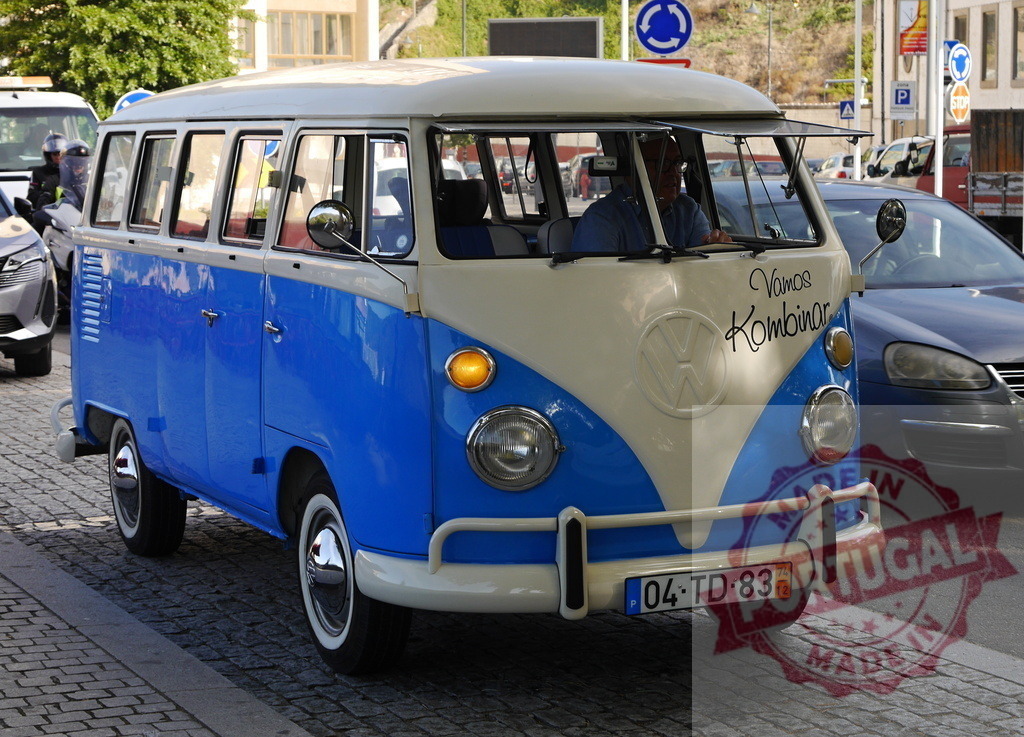 Volkswagen Type 2 driving on cobblestone street | Blue and white Volkswagen Type 2 van driving on a city street - Realized with Pictrs.com