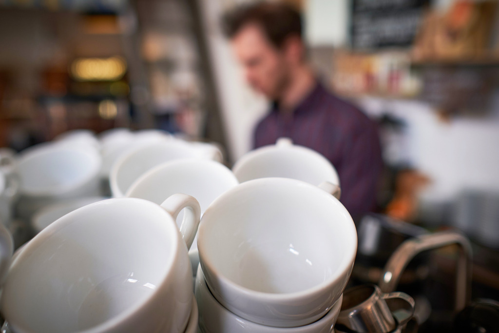 Café Comet | WIen, Austria - February 12, 2020: Café Comet; weiße Kaffeetassen auf der Ablage einer Siebträgermaschine, im Hintergrund Herr Haller. - Realisiert mit Pictrs.com