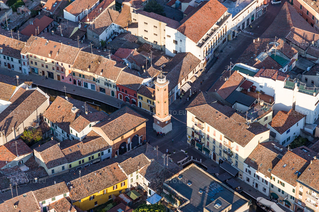 Vue aérienne: La tour Torre Civica se dresse sur une place au milieu d'étroites rues historiques d'Émilie-Romagne. à Comacchio dans le département Ferrara, Italie – .Photo: IMG_098684.jpg prise le 06/04/2017 par Werner Riehm/FLY-FOTO.eu – Résolution de l'original: 4981 x 3321 px
