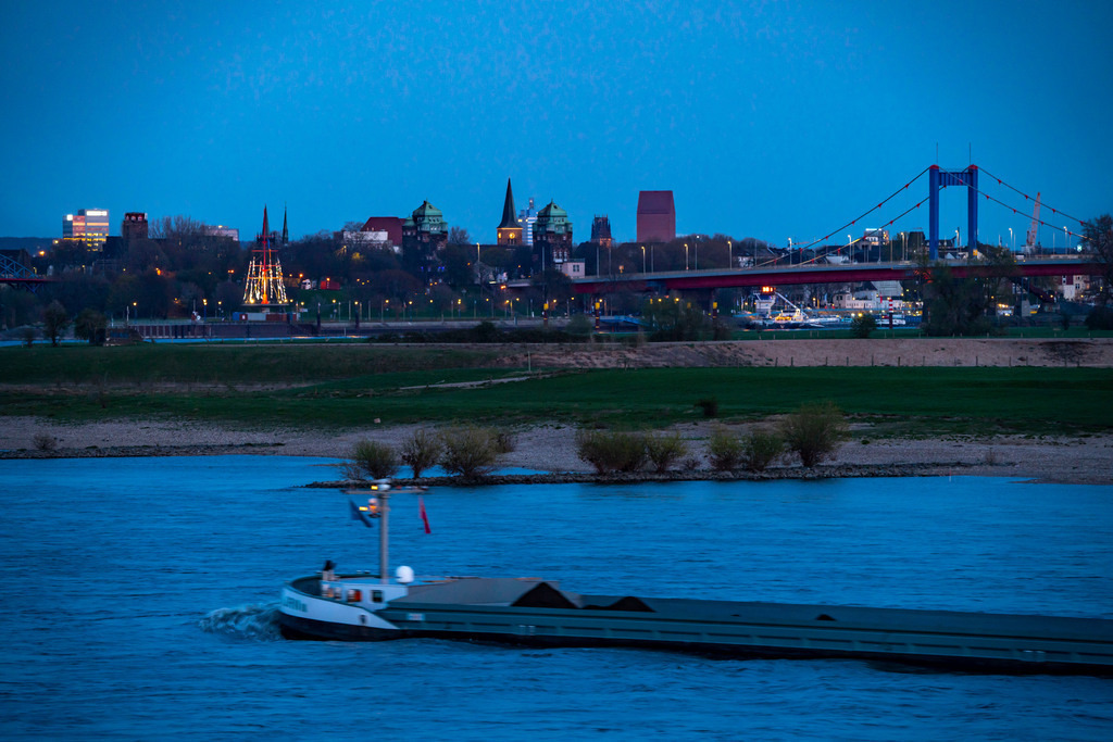 JT-210413 | Frachtschiff auf dem Rhein bei Duisburg-Beeckerwerth, Skyline der Innenstadt, mit Rathaus, NRW Landesarchiv Turm, Friedrich-Ebert-Brücke, Duisburg, NRW, Deutschland  - Realisiert mit Pictrs.com