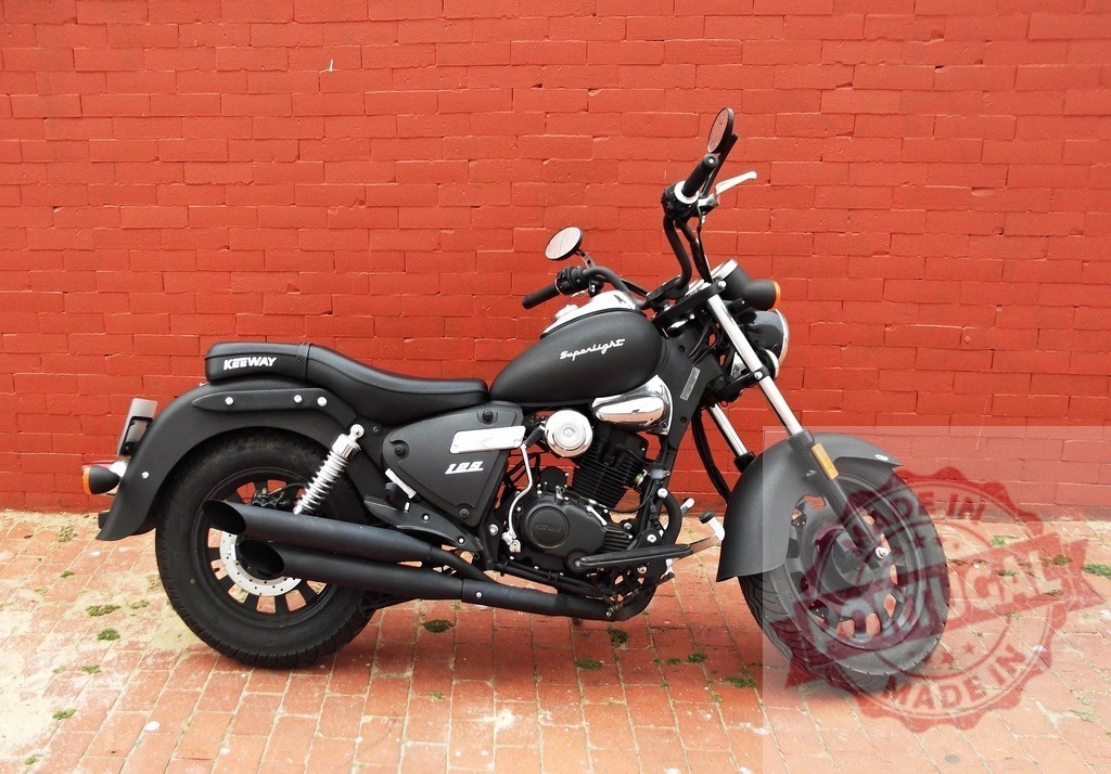 Keeway Superlight motorcycle parked against red brick wall | Black Keeway Superlight cruiser motorcycle parked outdoors - Realisiert mit Pictrs.com