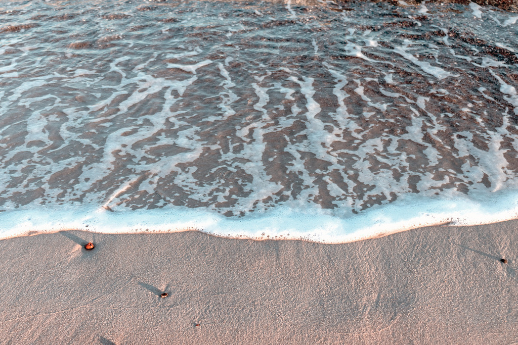Wandbild: Welle im Morgenrot | Dieses Wandbild im Querformat zeigt eine Welle, die gerade am Strand ausläuft. Der Sand am Strand hat einen leichten rötlichen Ton, da er von der morgendlichen Sonne angestrahlt wird. Kaufen Sie sich diese schöne maritime Morgenstimmung auf Leinwand, Aluminium-Platte oder Acrylglas. Ideal fürs Wohnzimmer, Schlafzimmer, Küche, den Arbeitsplatz oder die Ferienwohnung. Die Wandbilder werden individuell für Sie in vielen Abmessungen produziert. Daher passen die Ostseekult Wandbilder immer perfekt an Ihre Wände. - Realisiert mit Pictrs.com