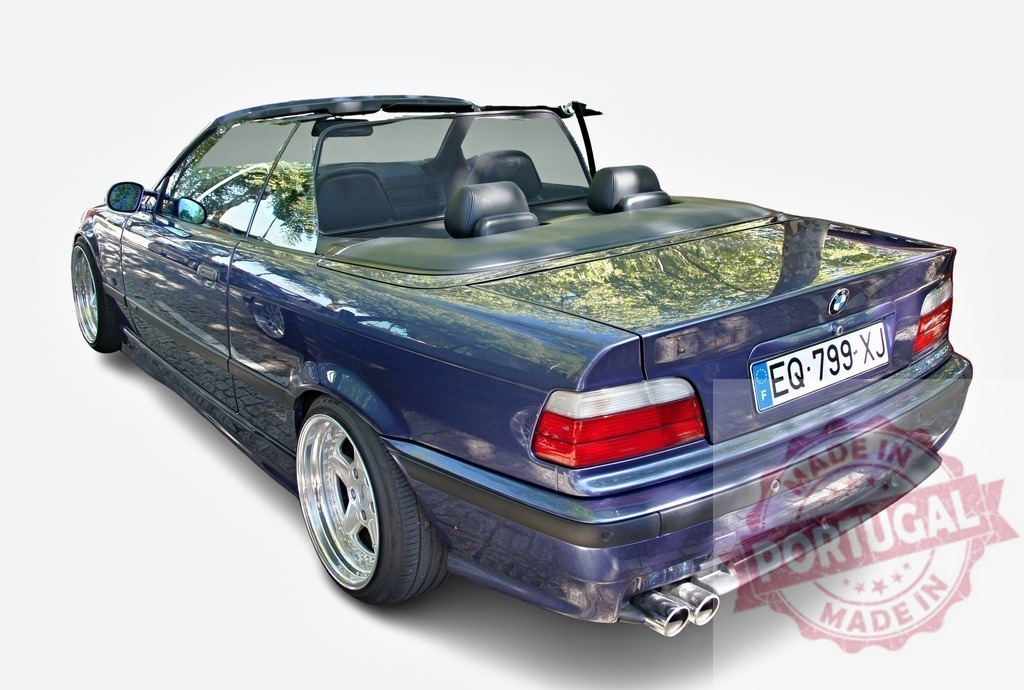 Rear view of tuned BMW convertible with wind deflector showing reflections of trees | Dark blue BMW series 3 e36 convertible parked with its top down and a wind deflector reflecting trees - Realisiert mit Pictrs.com