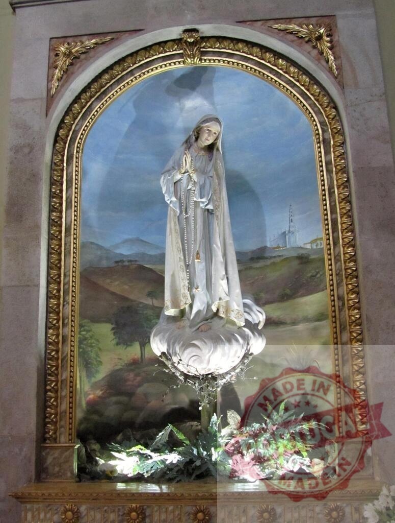 Statue of Virgin Mary praying with rosary in church alcove | Beautiful statue of Virgin Mary praying with rosary in church alcove with painted background and plants - Realisiert mit Pictrs.com