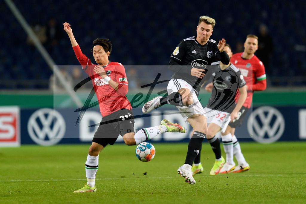 H96DUS20211027_005 | Fussball, Herren: Sei Muroya (Hannover 96) und Felix Klaus (Fortuna Duesseldorf) im Zweikampf bei dem Spiel der 2. Runde im DFB-Pokal zwischen Hannover 96 und Fortuna Duesseldorf in der HDI-Arena am 27.10.2021 in Hannover, Deutschland.DFB / DFL REGULATIONS PROHIBIT ANY USE OF PHOTOGRAPHS AS IMAGE SEQUENCES AND/OR QUASI-VIDEO. - Realisiert mit Pictrs.com