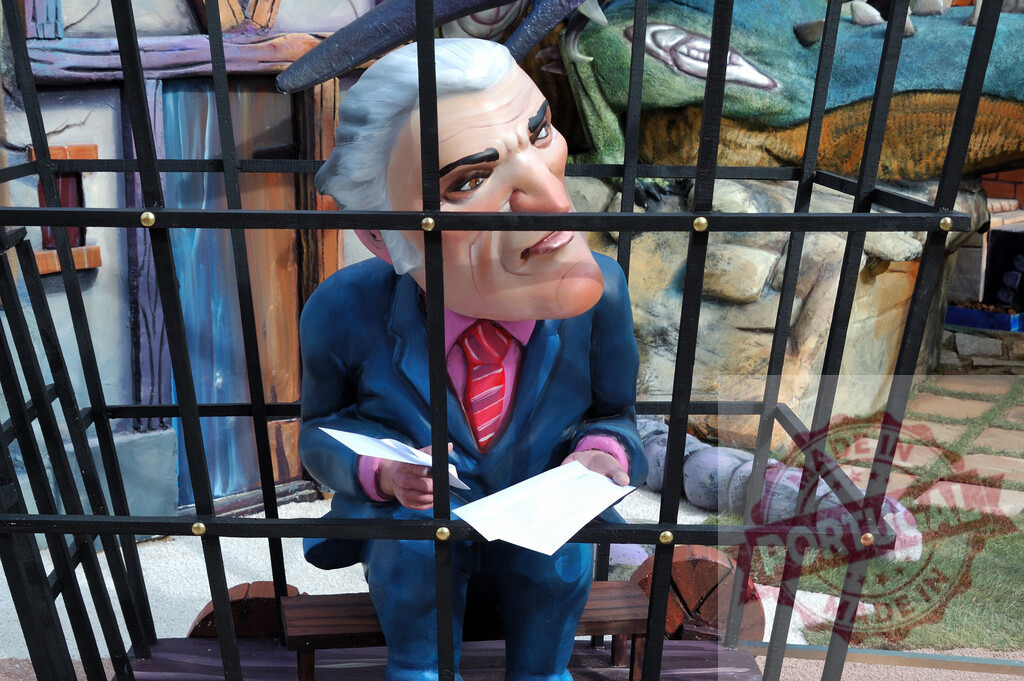 Nicholas Sarkozy caricature in cage representing political satire | Nicholas Sarkozy caricature sculpture caged, holding papers, a symbol of political satire - Realisiert mit Pictrs.com