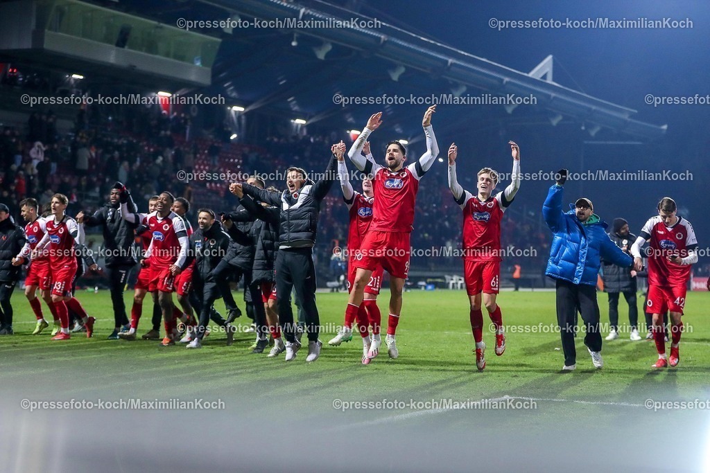 FCVK14022501106 | 14.02.2025, Fußball, FC Viktoria Köln – Alemannia Aachen, 3.Liga, Sportpark Höhenberg, Saison 2024 2025: Abschlussjubel nach dem 3:1 Sieg für Viktoria Köln. Die Mannschaft steht jubelnd zusammen auf dem Spielfeld und bedankt sich bei den Fans für die Unterstützung. rechts: Tobias Eisenhuth (Viktoria Köln #21), Lex-Tyger Lobinger (Viktoria Köln #9), Bryan Henning (Viktoria Köln #6)DFB regulations prohibit any use of photographs as image sequences and or quasi-video.