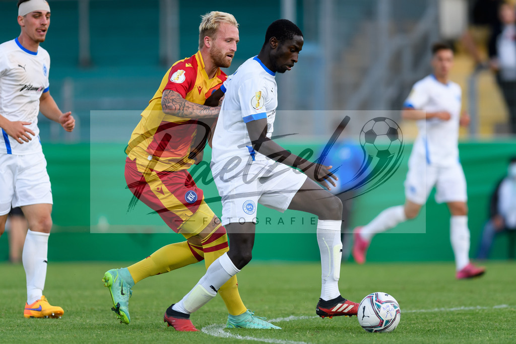 LOTKSC20210809_187 | Fussball, Herren: Philipp Hofmann (Karlsruher SC) und Komlan Fionouke (Sportfreunde Lotte) im Zweikampf beim Spiel der 1. Runde im DFB-Pokal zwischen SF Lotte und Karlsruher SC im Stadion am Lotter Kreuz am 09.08.2021 in Lotte, Deutschland.DFB / DFL REGULATIONS PROHIBIT ANY USE OF PHOTOGRAPHS AS IMAGE SEQUENCES AND/OR QUASI-VIDEO. - Realisiert mit Pictrs.com