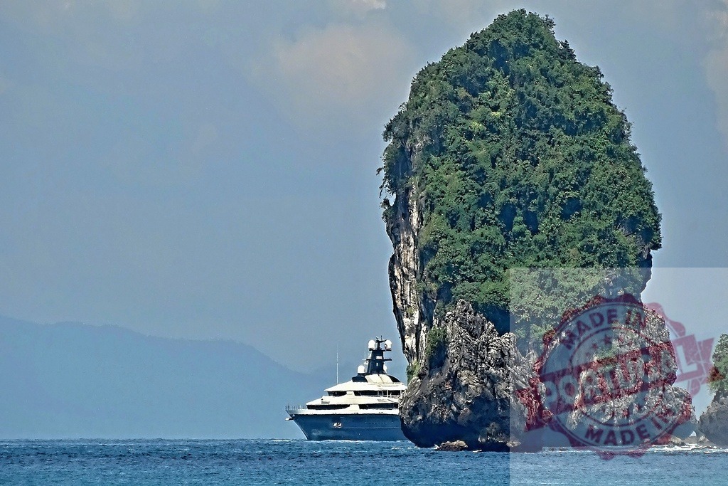 Luxury yacht sailing near a small island in Thailand | Modern yacht sailing in the Andaman Sea, near a characteristic limestone cliff covered in vegetation - Realized with Pictrs.com