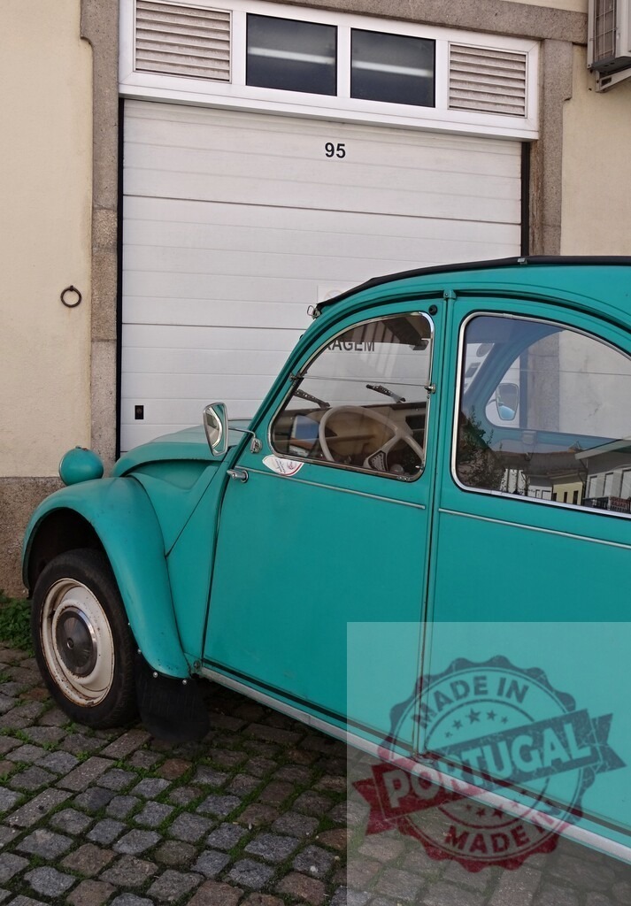 Classic turquoise Citroën 2CV on a cobblestone street | Turquoise Citroën 2CV car parked on cobblestone next to a garage door - Realized with Pictrs.com