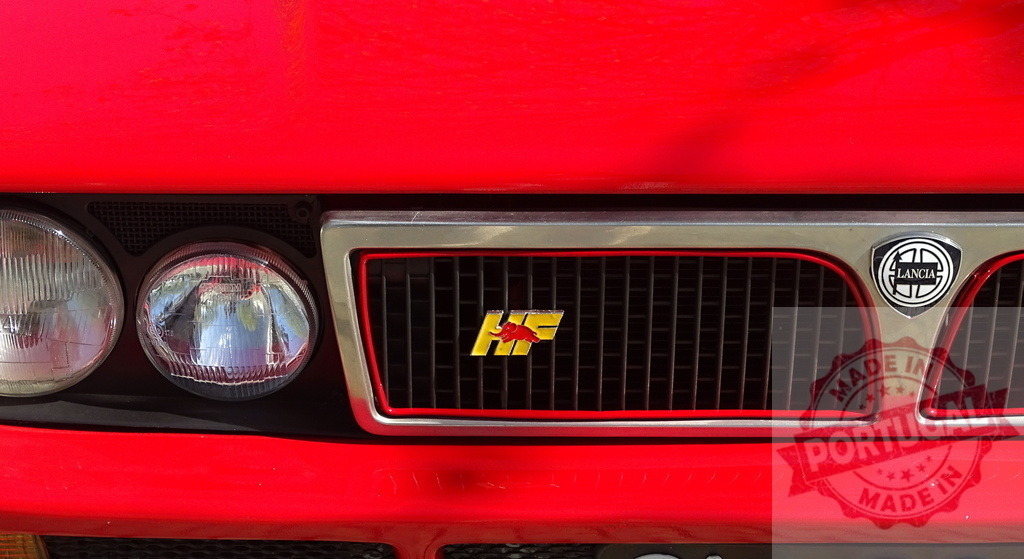 Lancia Delta Integrale HF logo on red car grille | Lancia Delta Integrale HF logo and grille on a classic red rally car - Realized with Pictrs.com