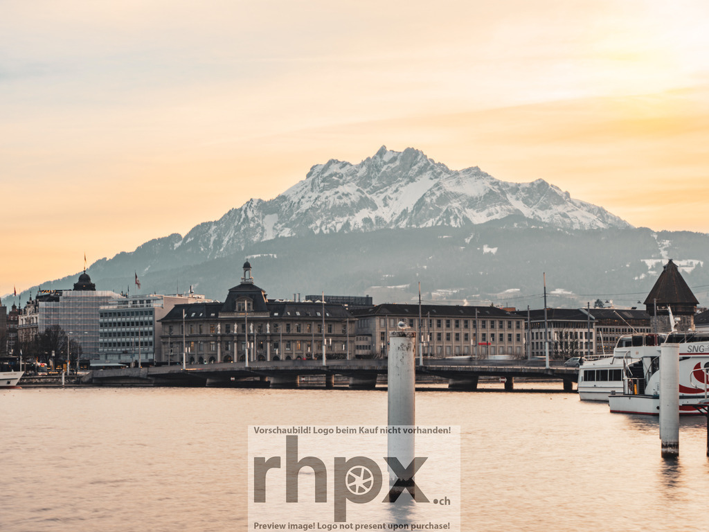 Luzern vor dem Pilatus | Stadt. Berg. Abendlicht.Der Blick ueber die Seebruecke von Luzern offenbart die markante Silhouette des schneebedeckten Pilatus waehrend der goldenen Stunde.Die malerische Stimmung und die feinen Strukturen der Bergkette kommen auf Hahnemuehle Fineart besonders edel zur Geltung. Waehle unter 'Produktauswahl' dein Wunschformat als Wandbild, Puzzle oder hochwertigen Download. - Realisiert mit Pictrs.com