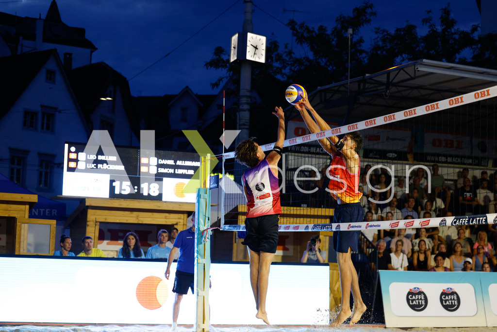 Obi BeachTour 2026 - Basel | BASEL, SWITZERLAND - JULY 17: SIMON LEFFLER (SUI) attack / spike against LUC EMANUEL FLÜCKIGER (SUI) block during the Obi BeachTour 2026 match between DILLIER / FLÜCKIGER (SUI) and ALLEMANN / LEFFLER (SUI) at Barfüsserplatz on July 17, 2026 in Basel, Switzerland. - Realisiert mit Pictrs.com