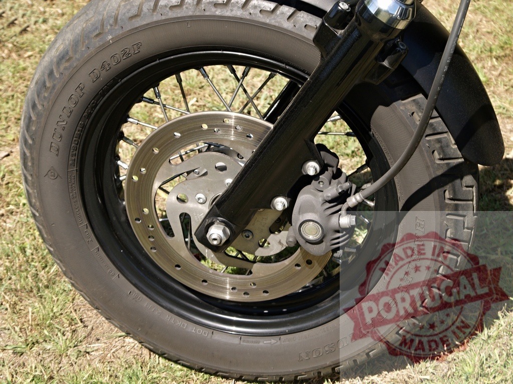 Front wheel of a Harley-Davidson motorcycle showing tire, brake disc and spokes | Close-up of a Harley-Davidson motorcycle front wheel highlighting the tire, brake disc, and spokes - Realized with Pictrs.com