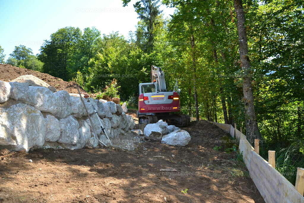 Steinschlichtung Kalkstein | Baggerarbeit Errichtung Steinmauer aus großen Kalksteinen, Hangsicherung.