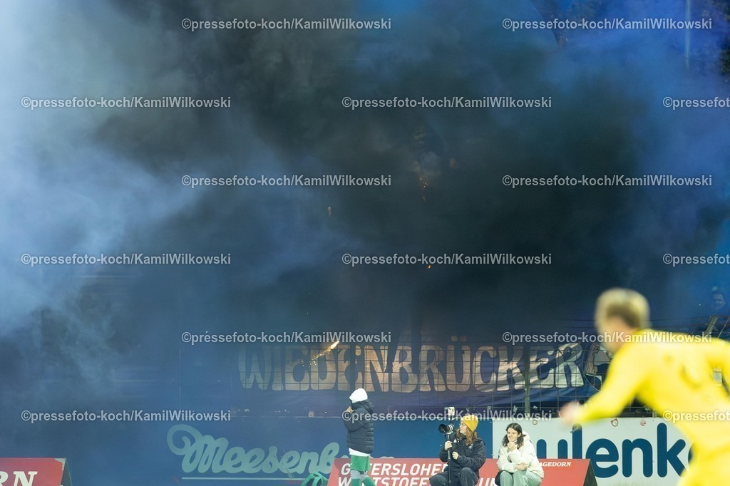 xKWI03102501128 | 03.10.2025, xkwix, Fußball, Regionalliga West, FC Gütersloh - SC Wiedenbrück, Ohlendorf Stadion im Heidewald: Pyro im Gästeblock 