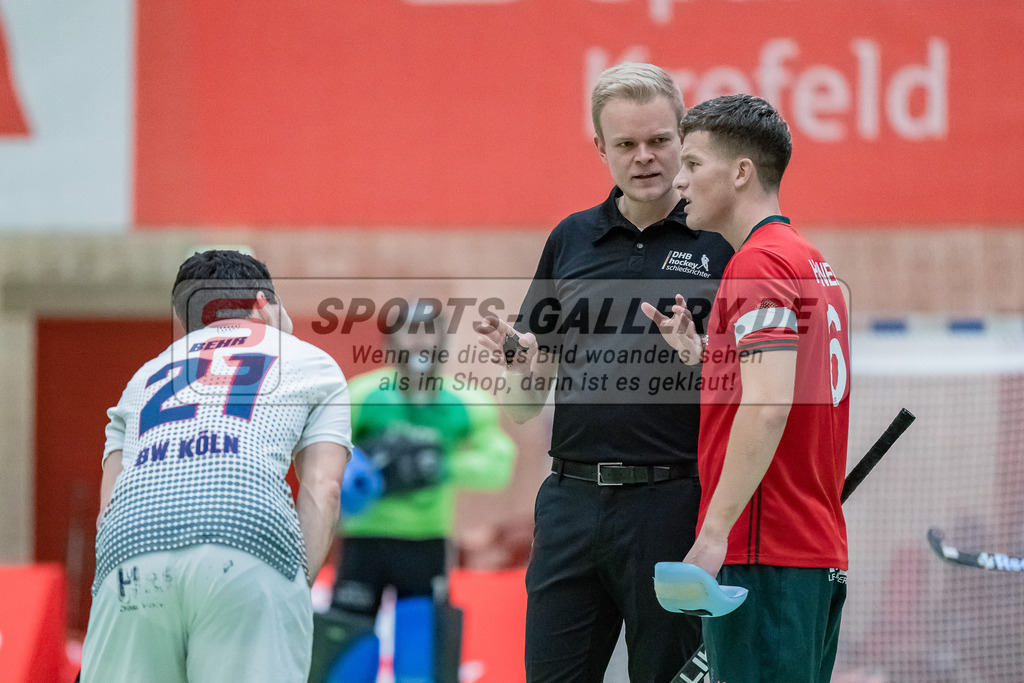 HK_20231216_107427 | 1. Bundesliga Herren  Crefelder HTC - Blau Weiß Köln am 16.12.2023 Sporthalle Glockenspitz, Krefeld , Sebastian Behr ( Blau Weiß Köln #21 ) , Hendrik Völker ( SR ) , Julius Hayner ( Crefelder HTC #6 )