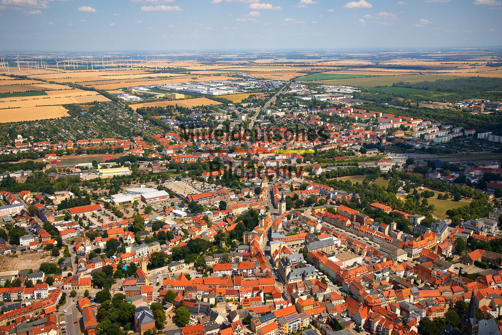 Aschersleben-Salzlandkreis-Sachsen-Anhalt_2185 | Die Luftaufnahme zeigt Aschersleben mit seiner historischen Innenstadt und den angrenzenden Stadtquartieren. Markante Kirchen, Türme und erhaltene Teile der Stadtbefestigung erinnern an die lange Geschichte der ältesten Stadt Sachsen-Anhalts. Aus der Vogelperspektive werden die kompakte Altstadt und die Entwicklung der Stadt über ihre historischen Grenzen hinaus besonders gut sichtbar. - Realisiert mit Pictrs.com